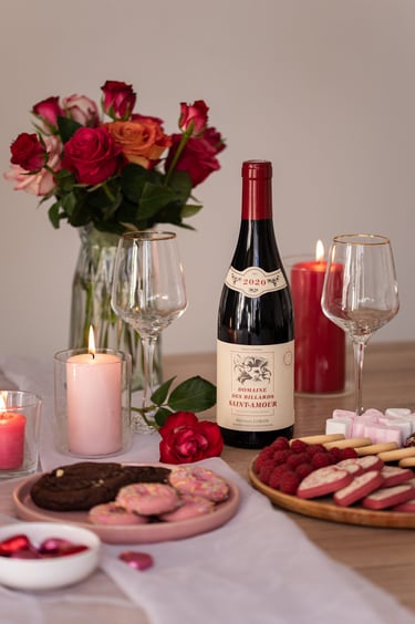 une table de Saint-Valentin avec un bouteille de vin et des verres à pied