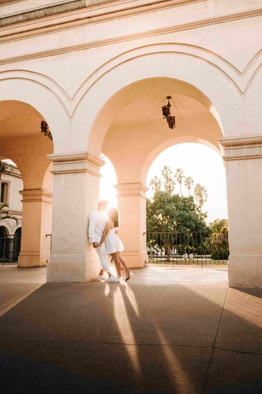 A photo of a young couple kissing under ornate pillars