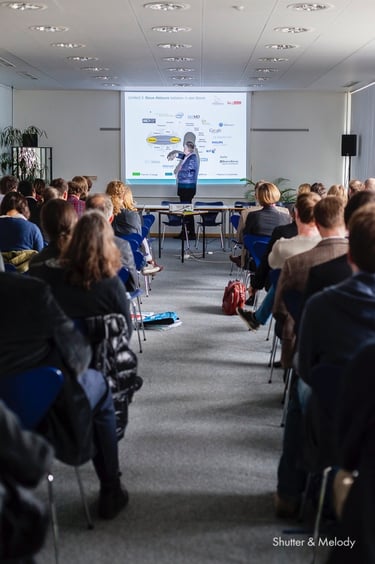 Ein Mann, der während einer CBMI-Konferenz eine PowerPoint-Präsentation hält.