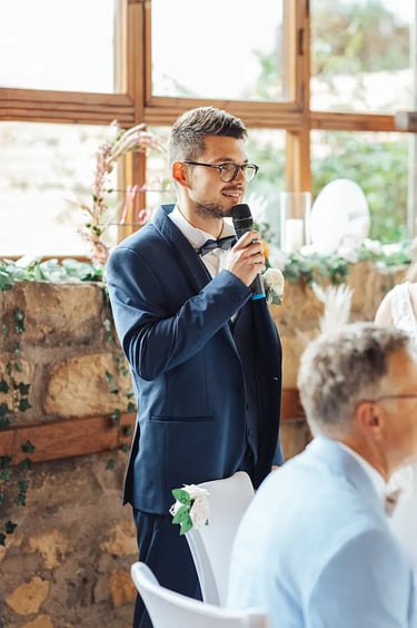 Marié, micro en main, en train de faire un discours.