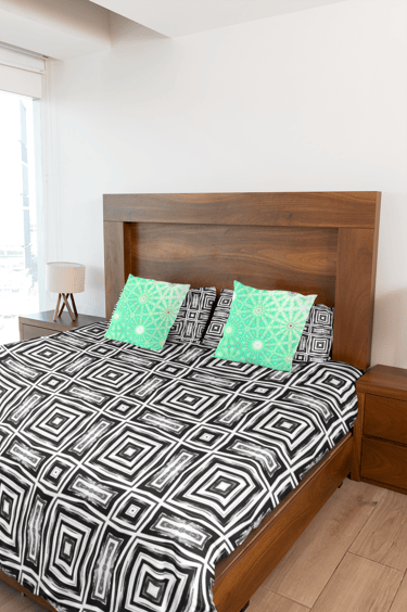 Bed with throw pillows and a duvet cover on it