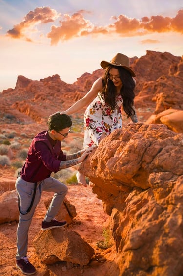 a man and woman holding hands on a rock