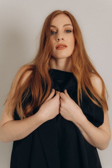 a woman with red hair and a black jacket
