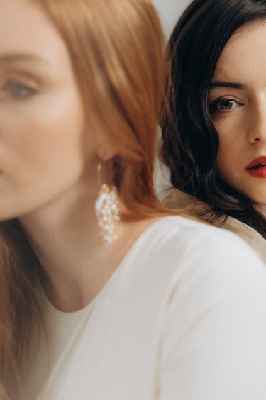 two women with red lipstick and earrings