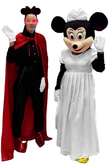 Two people in mouse costumes, one in a red cape and one in a white dress, waving at the camera.