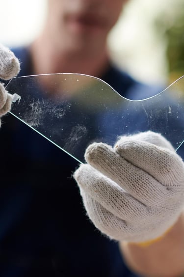 Technician handling shower glass panel with safety gloves