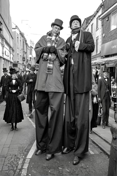 Performers in Victorian / Edwardian costumes on stilts at a Dickens festival street event.