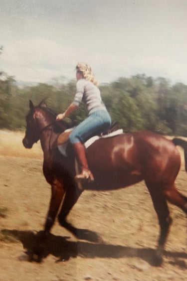 Nancy Jo riding her horse in a field