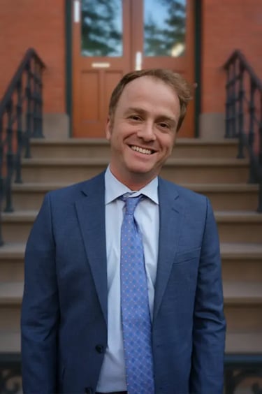 Attorney Jay Browne smiling in front of a Brownstone 