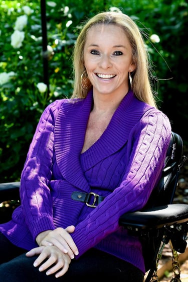 Headshot of Ali Ingersol shows her in a purple blouse in a scenic setting