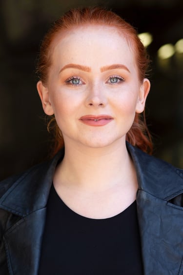 a woman with red hair and a black jacket