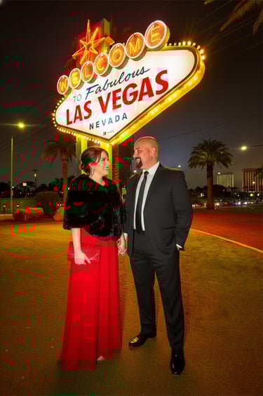 a man and woman standing in front of a las vegas sign