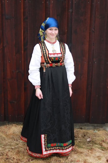 A woman wearing a head scarf and an empire waisted bunad