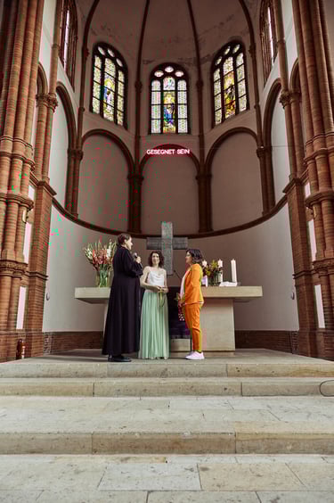 Female pastor speaking to two brides standing by the altar.