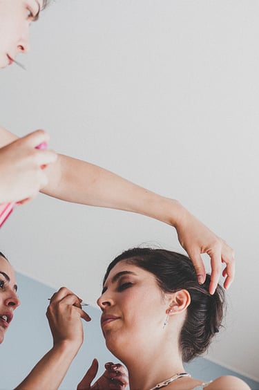 Brautjungfern geben dem Make-up und der Frisur der Braut den letzten Schliff.