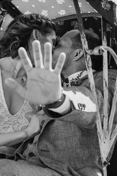 Der Bräutigam benutzt seine Hand als Schutz, während er die Braut küsst.