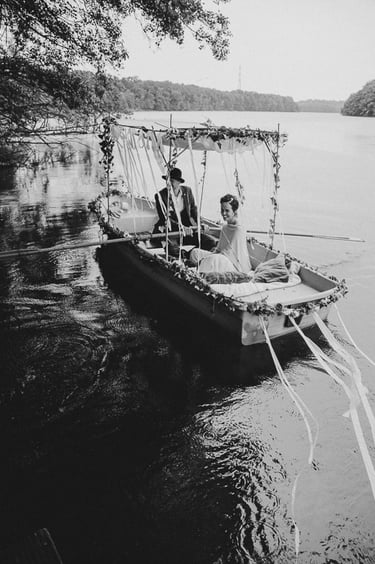 Bride and groom in a boat in a lake.