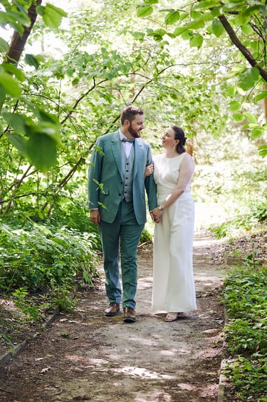 Bride and groom walking on a path in the botanical gardens.
