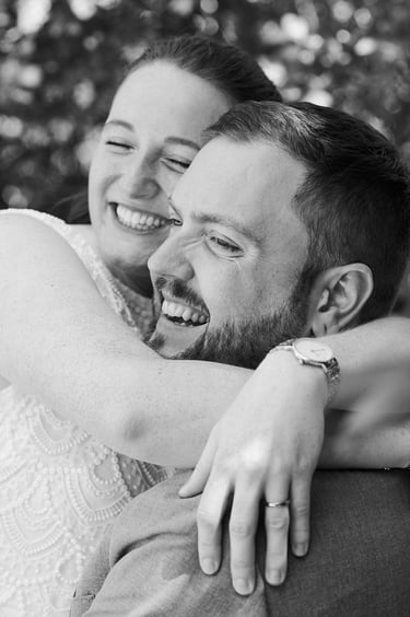 Braut und Bräutigam umarmen sich und lachen.