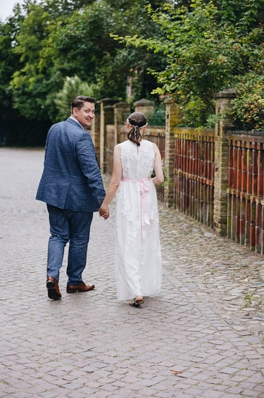 Braut und Bräutigam gehen einen Weg entlang.