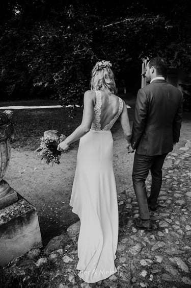 Braut und Bräutigam spazieren über Kopfsteinpflaster.