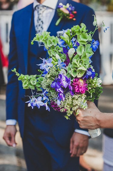 A hand of the bride holding her bouquet.
