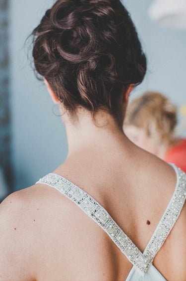 A bride's upper back and hairdo.