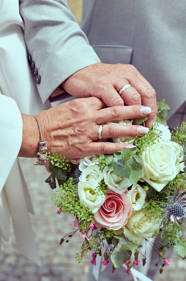 Close-up of bride's and groom's hands with wedding rings.