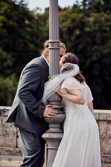 Bride and groom kissing behind a lamppost in Rudolph-Wilde-Park.