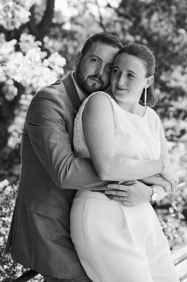 Bride leaning on groom while he hugs her from behind.