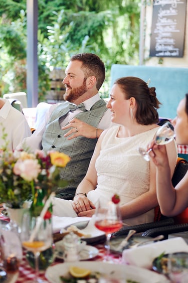 Bride and groom sitting in a restaurant during their reception.
