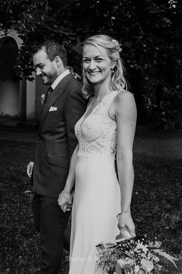 Bride looking into the camera while she is walking with the groom..