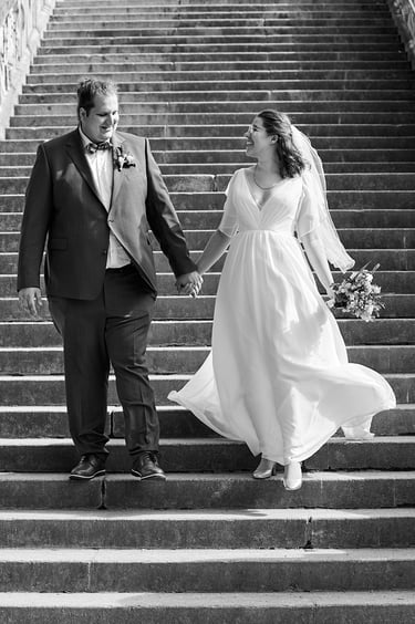 Smiling bride and groom walking down stairs.