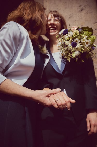 Bride kissing wife on the cheek.