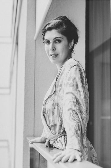 A portrait of a bride in a robe on a balcony.