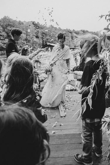 Bride being greeting by wedding guests on a pier.