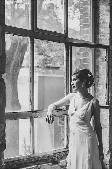 A portrait of a bride looking out of a window.