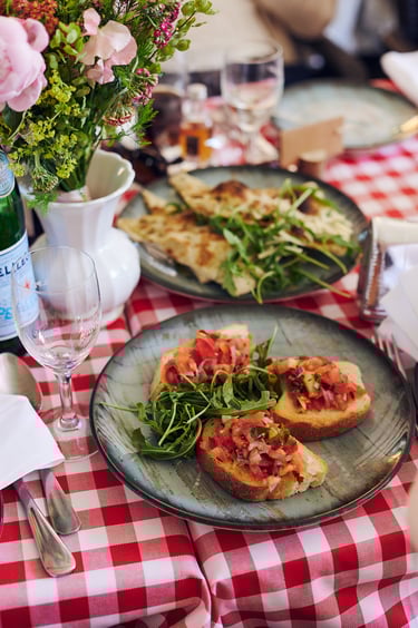 Bruschetta on a plate on a table with a checked table cloth.