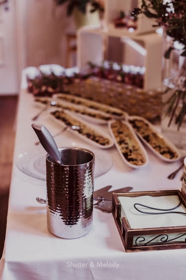 A cake knife in a silver water container on a table