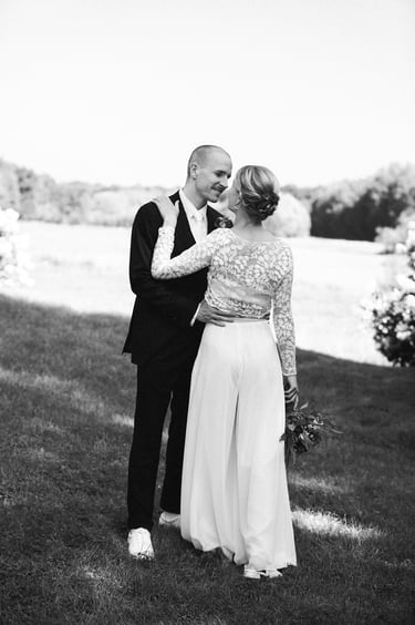 Bride and groom kissing with an open field in the background.