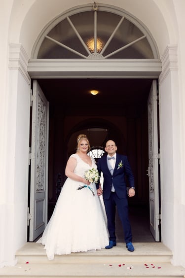 A newlywed couple standing in a doorway.