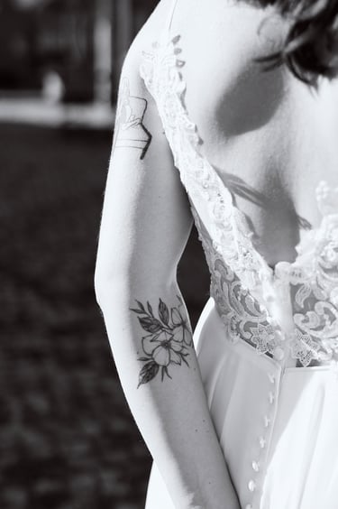 Bride's arm with a tattoo of a flower.