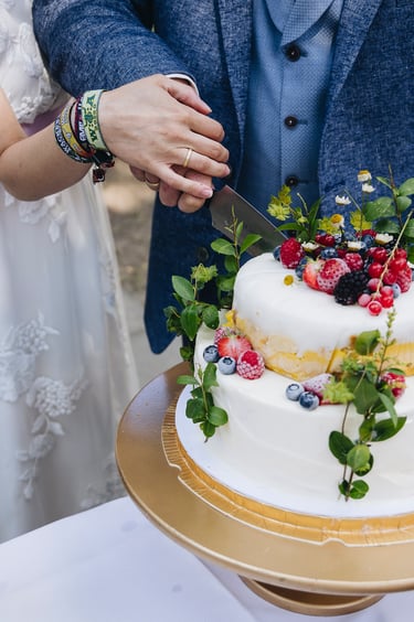 Nahaufnahme des Anschneidens der Eistorte bei der Hochzeit.