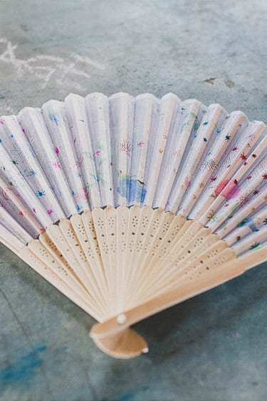 A fan lying on a blue table.