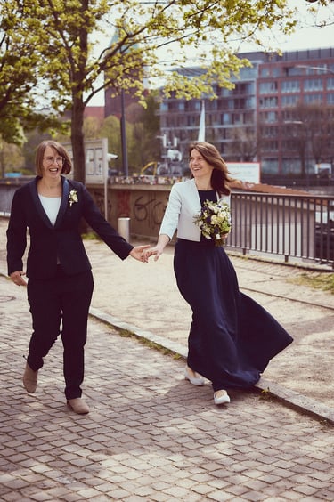Ein frisch verheiratetes lesbisches Paar geht spazieren und hält sich an den Händen.