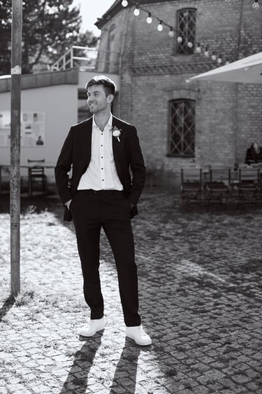 Full body portrait of a groom looking to the side.