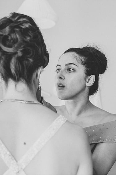 Eine völlig konzentrierte Brautjungfer, die das Make-up der Braut korrigiert.