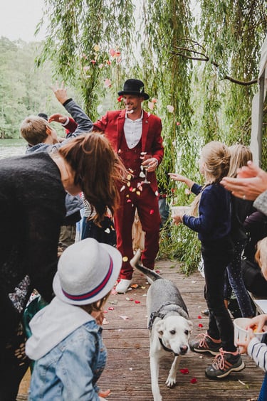 A groom on a pier greeted by wedding guests.
