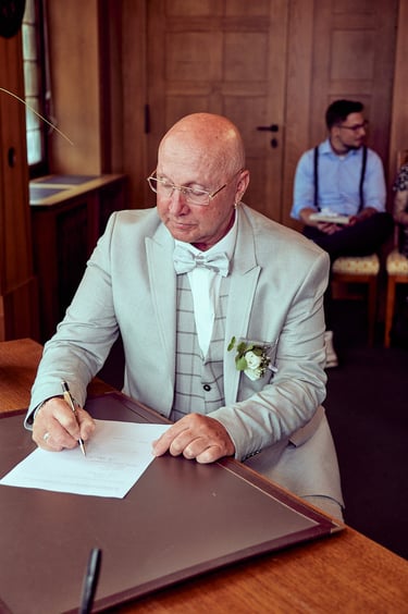 Groom signing marriage documents.