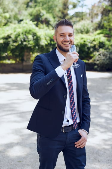 Smiling groom drinking a glass of sparkling wine.